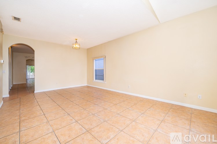 A spacious room with beige walls and a tiled floor.