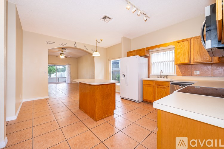 A kitchen with a refrigerator, counter, and cabinets.