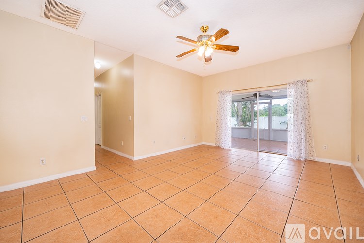 A spacious room with a ceiling fan and tile flooring.