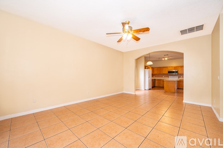 A spacious room with a ceiling fan and tile flooring.