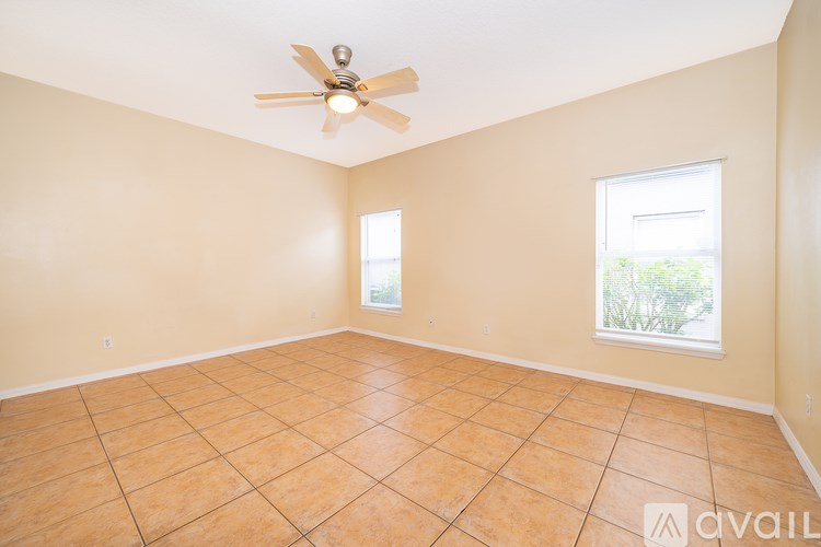 Empty room with tile floor and ceiling fan.