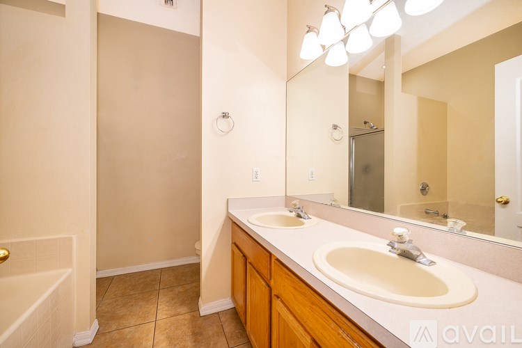 A bathroom with a sink, mirror, and a shower.