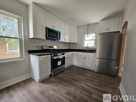 A kitchen with white cabinets and a black countertop.