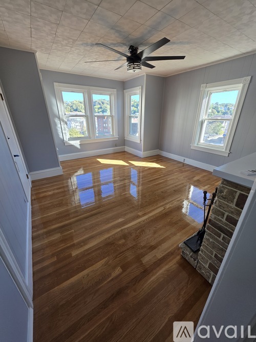 A room with wooden floors and a ceiling fan.