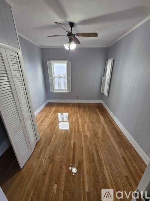 A room with wooden floors and a ceiling fan.