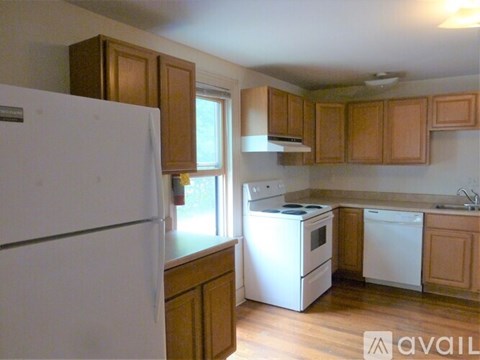 A kitchen with wooden cabinets and white appliances.
