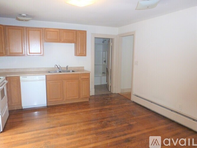 A kitchen with wooden cabinets and a white dishwasher.