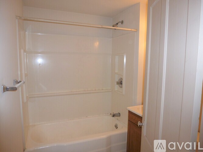 A bathroom with a bathtub and a towel rack.