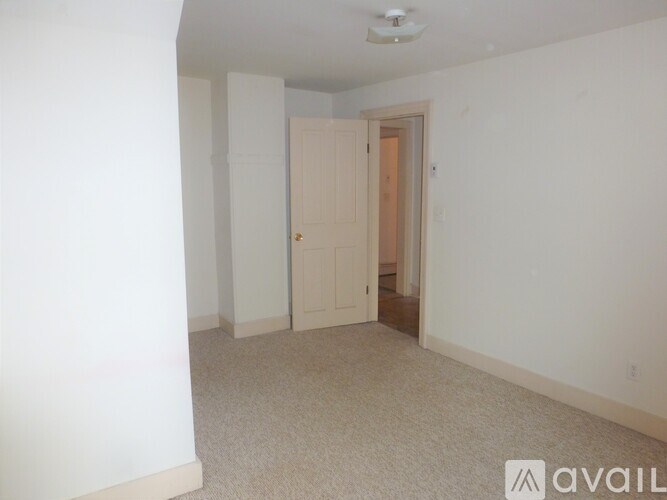 A room with a carpeted floor and a door.