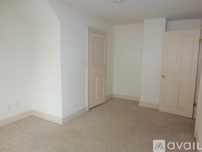 A room with two doors and a carpeted floor.
