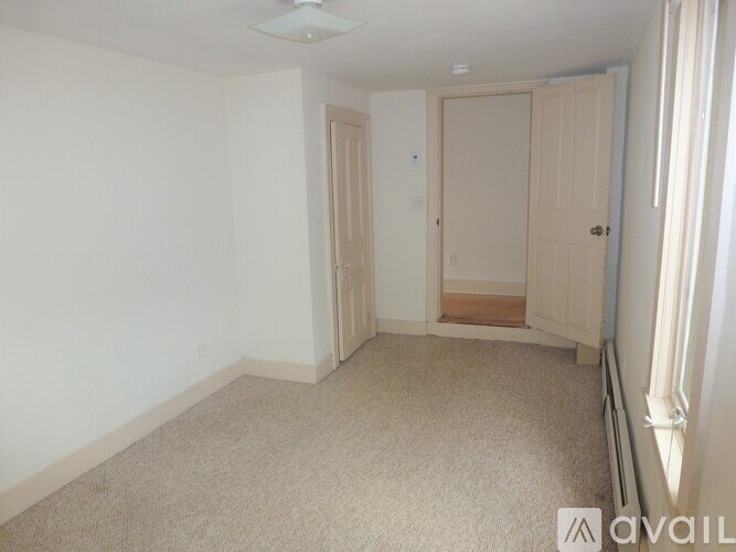 A room with two doors and a carpeted floor.