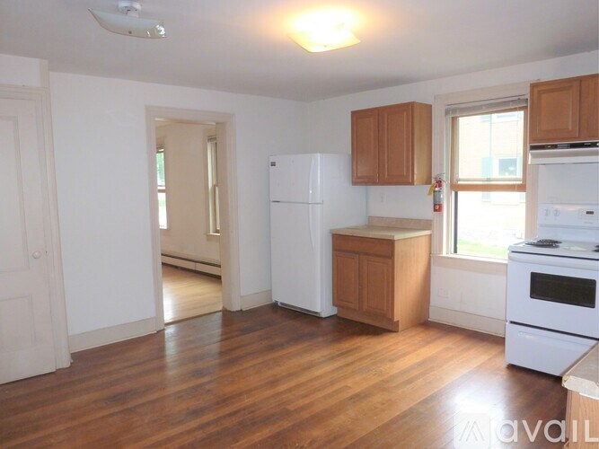 A kitchen with white appliances and wooden cabinets.