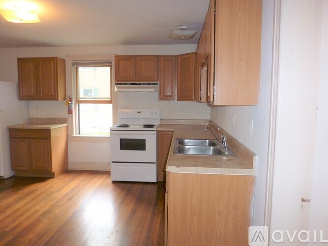 A kitchen with wooden cabinets and a white stove top oven.