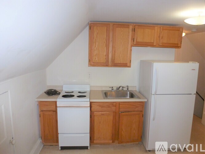 A kitchen with white appliances and wooden cabinets.