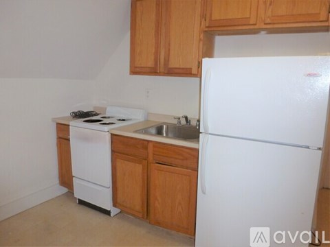 A kitchen with a white fridge, white stove and white dishwasher.