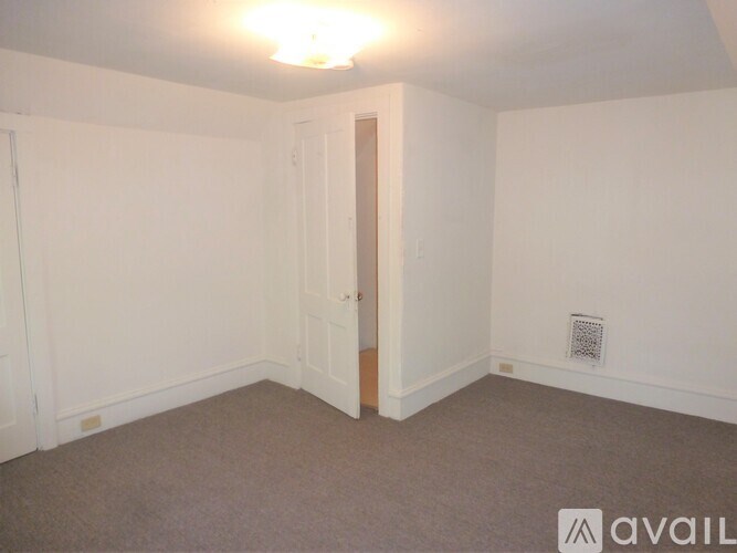 A room with a carpeted floor and a door.