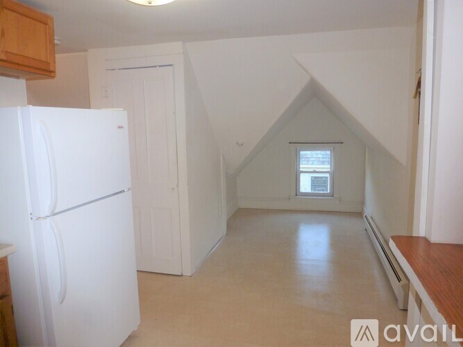 A kitchen with a white refrigerator and a window.