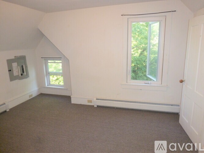 A room with a window and a door is available for rent.