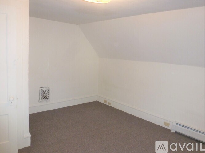 A room with a carpeted floor and a white door.