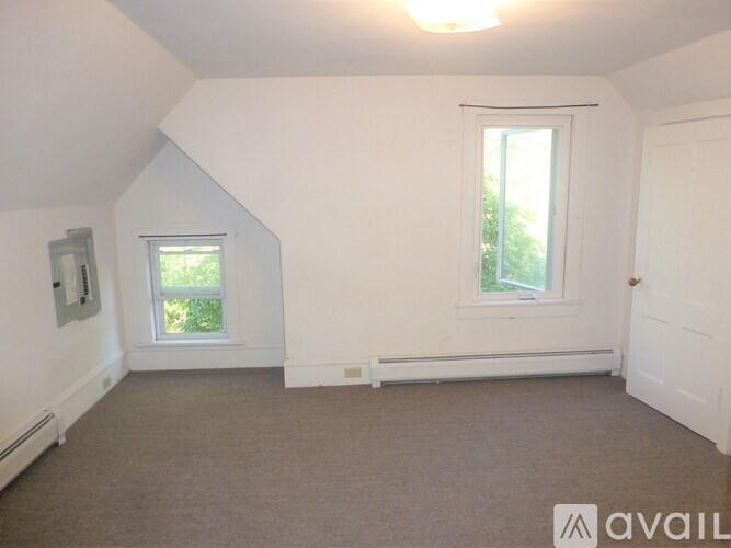 A room with a window and a door is available for rent.