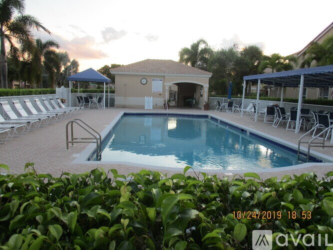 A pool area with a blue tarp and a white building.