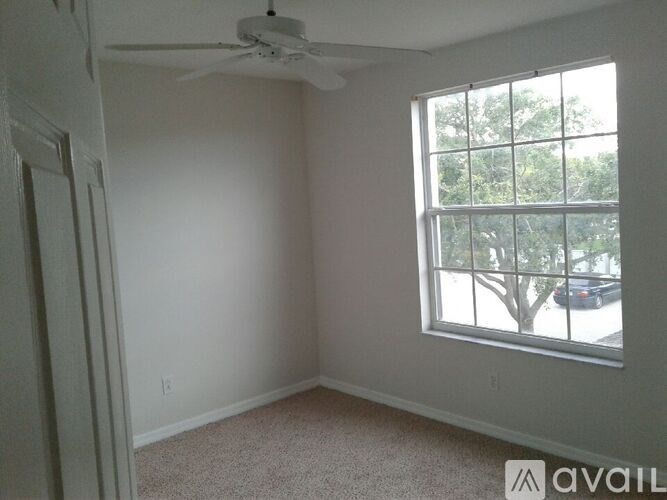 A room with a window and a fan on the ceiling.