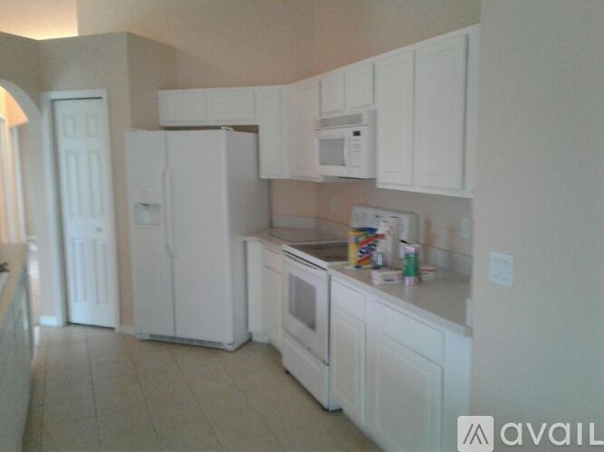 A kitchen with white appliances and cabinets.