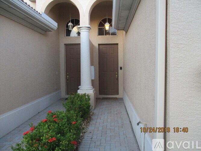 A white column stands in the middle of a hallway with two doors.