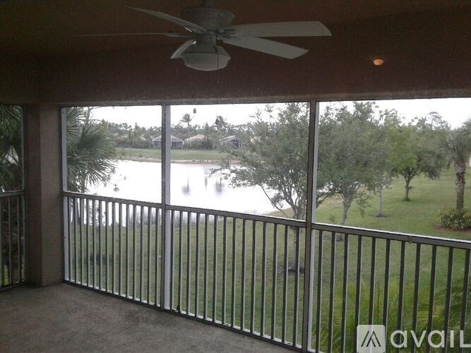A balcony with a fan and a view of a lake.