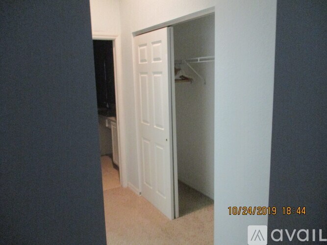 A white closet door is open in a room.