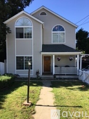 A house with a white fence and a black roof.