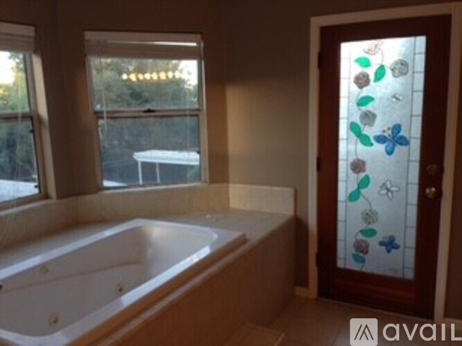 A bathroom with a tub and a glass door.