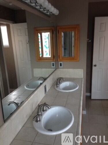 A bathroom with a large mirror and three sinks.