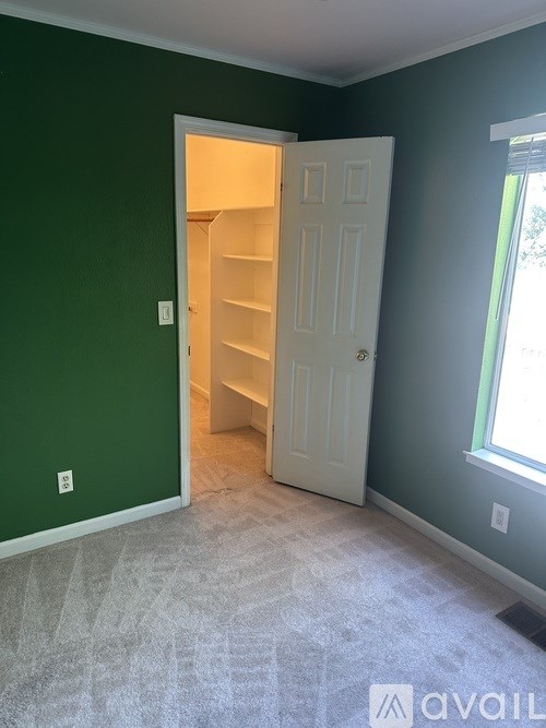 A room with a white door and a carpeted floor.