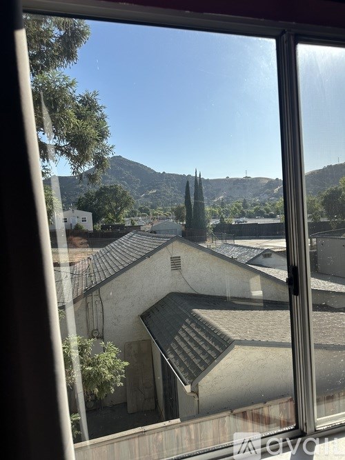 A view from a window looking out at a mountain.