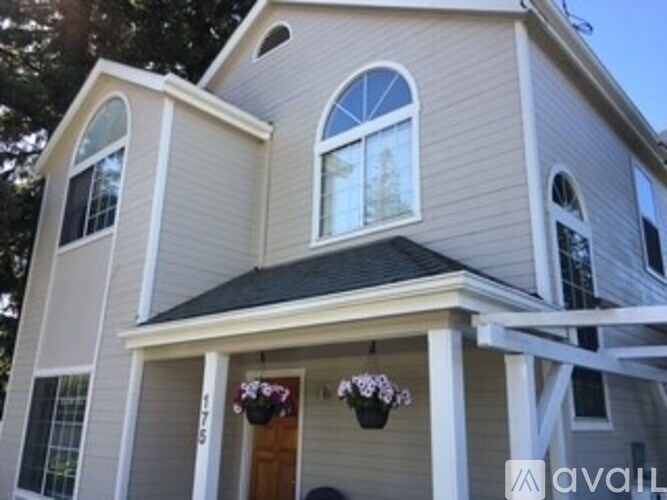 A house with a grey siding and a brown door.