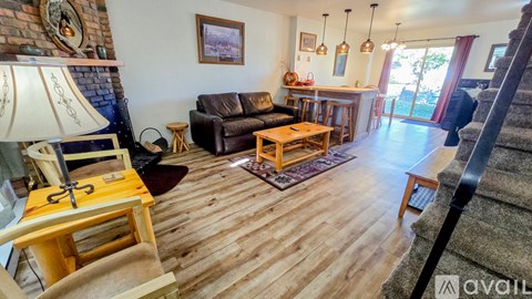 A living room with a brown couch and a wooden floor.