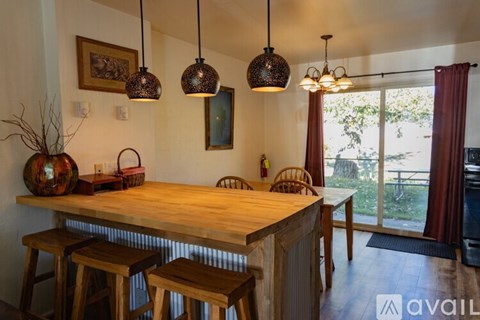 A kitchen with a wooden table and chairs.