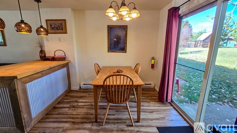 A dining room with a wooden table and chairs.