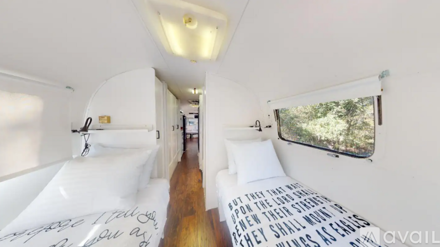 A bedroom with a bed and a window with a view of trees.