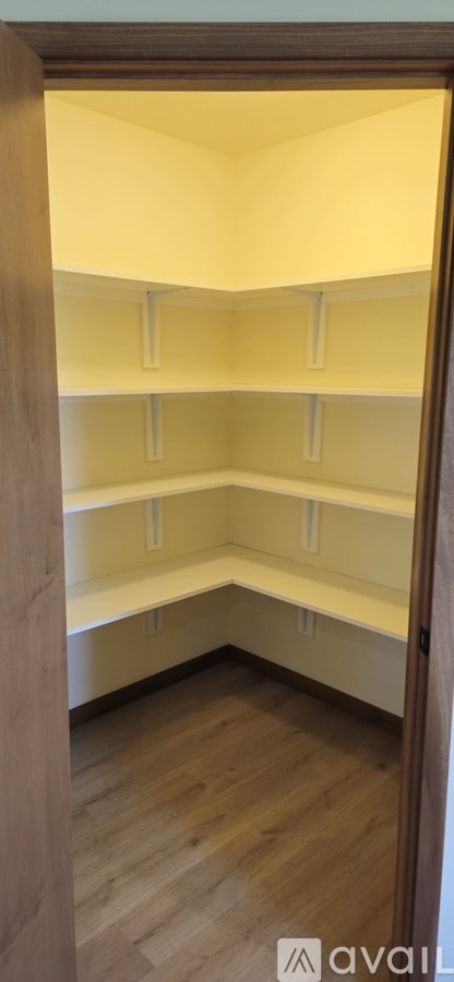 Empty shelves in a room with wooden flooring.