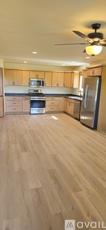 A kitchen with wooden cabinets and a refrigerator.