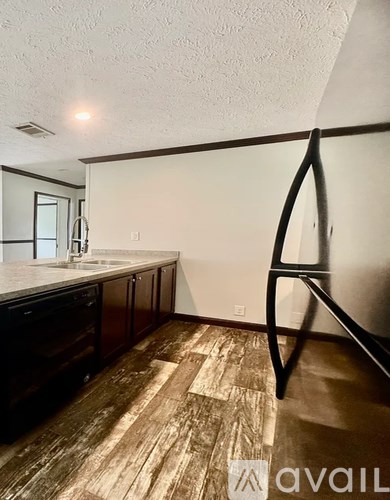 A kitchen with dark wood floors and white walls.