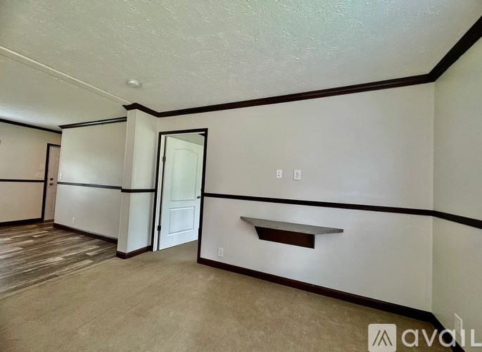 A room with a door and a window with a white wall.