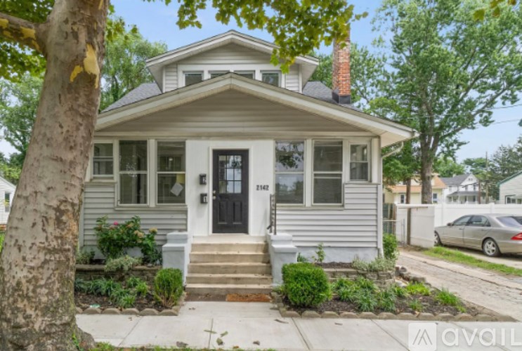 A house with a black front door is for sale.