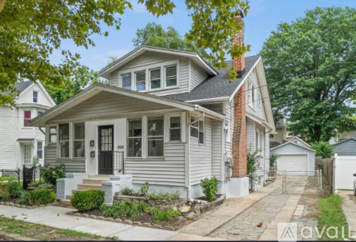 A two-story house with a grey exterior and a black front door.