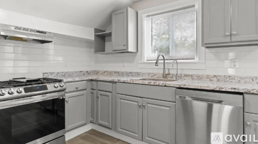 A kitchen with a stove, dishwasher, and cabinets.