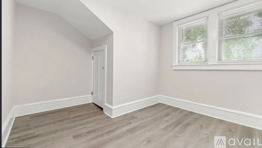 A room with a door and a window with blinds.