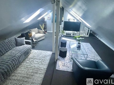 A living room with a grey couch and a black chair.