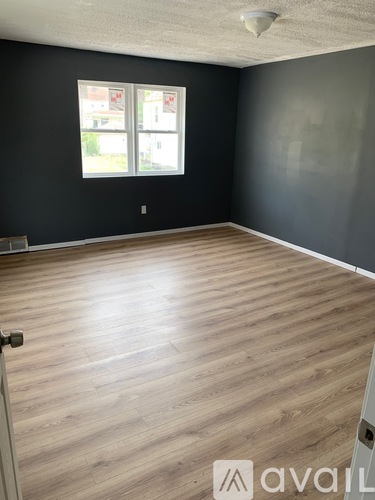 A room with wooden flooring and a window.